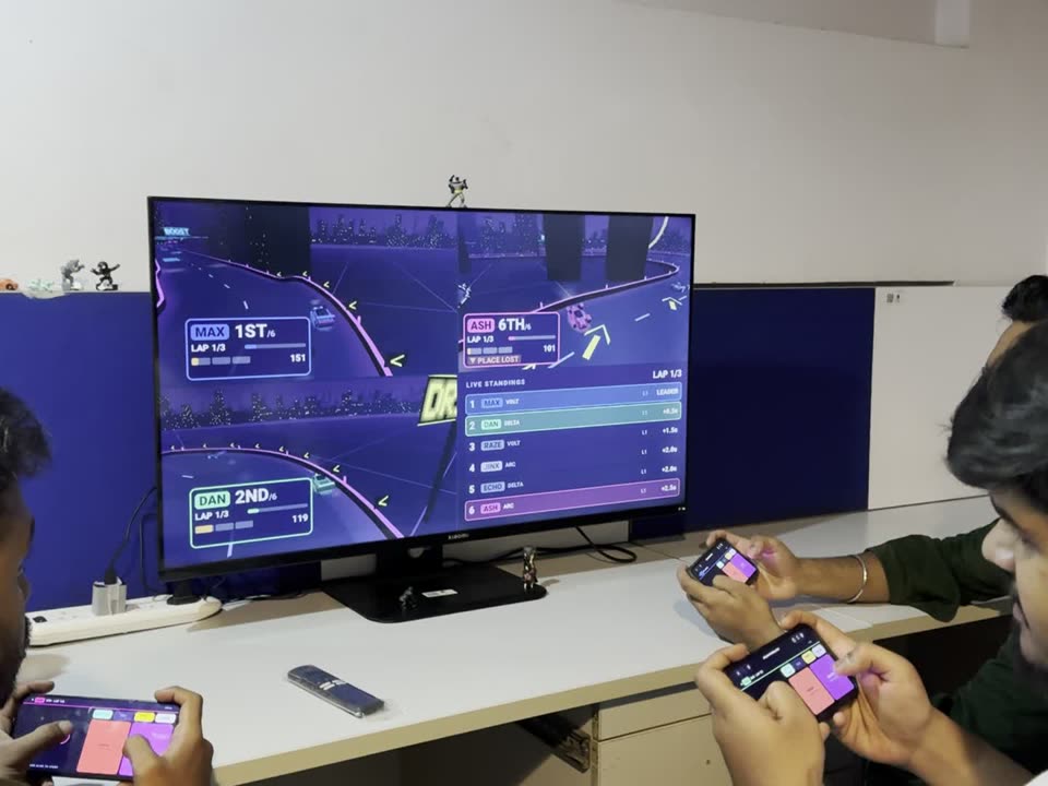 Friends racing on the TV, steering with their phones